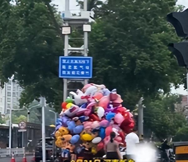 河南新乡一女子无视安全提示，在高压线下售卖气球，目击者：感觉挺“叛逆”的，上面是高压线，存在安全隐患
